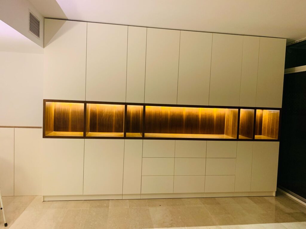 Full-height cream joinery run with a backlit display niche