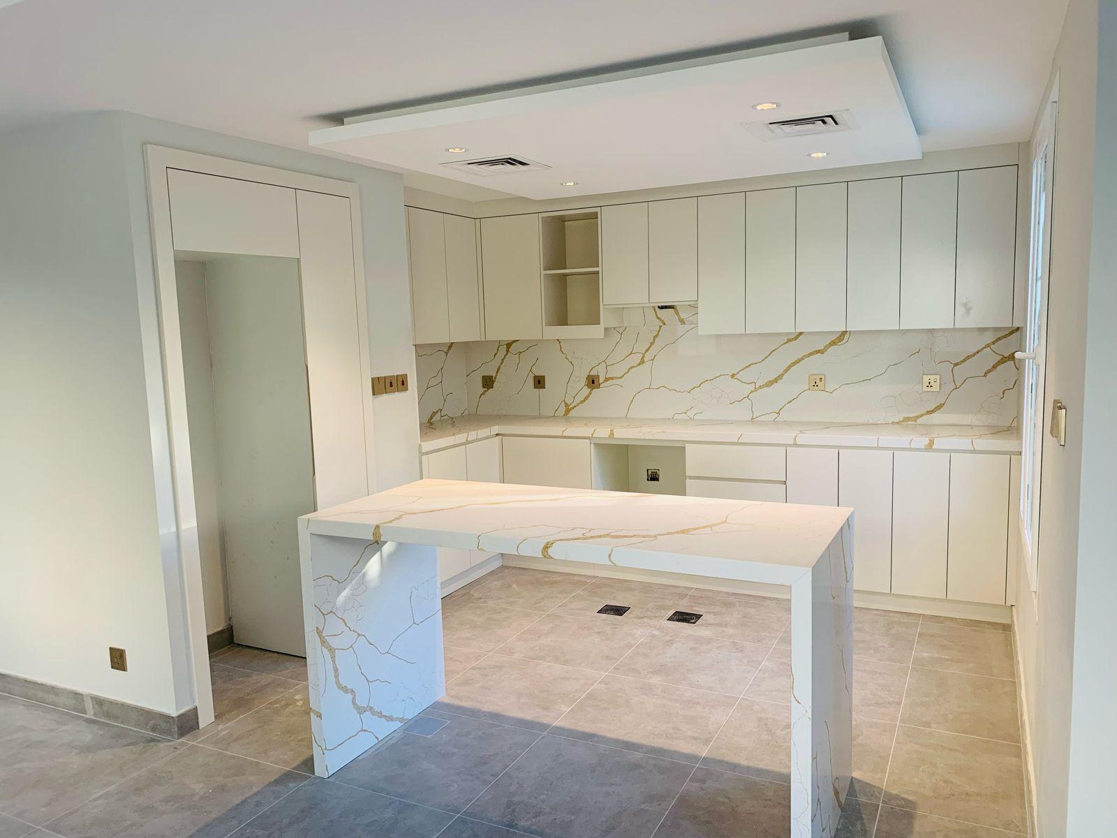 Full kitchen width view — handleless cabinets and Calacatta marble