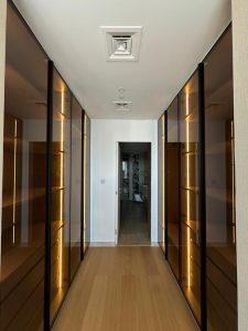 Walk-in wardrobe corridor at Canal Front CF09A by ASM Interiors