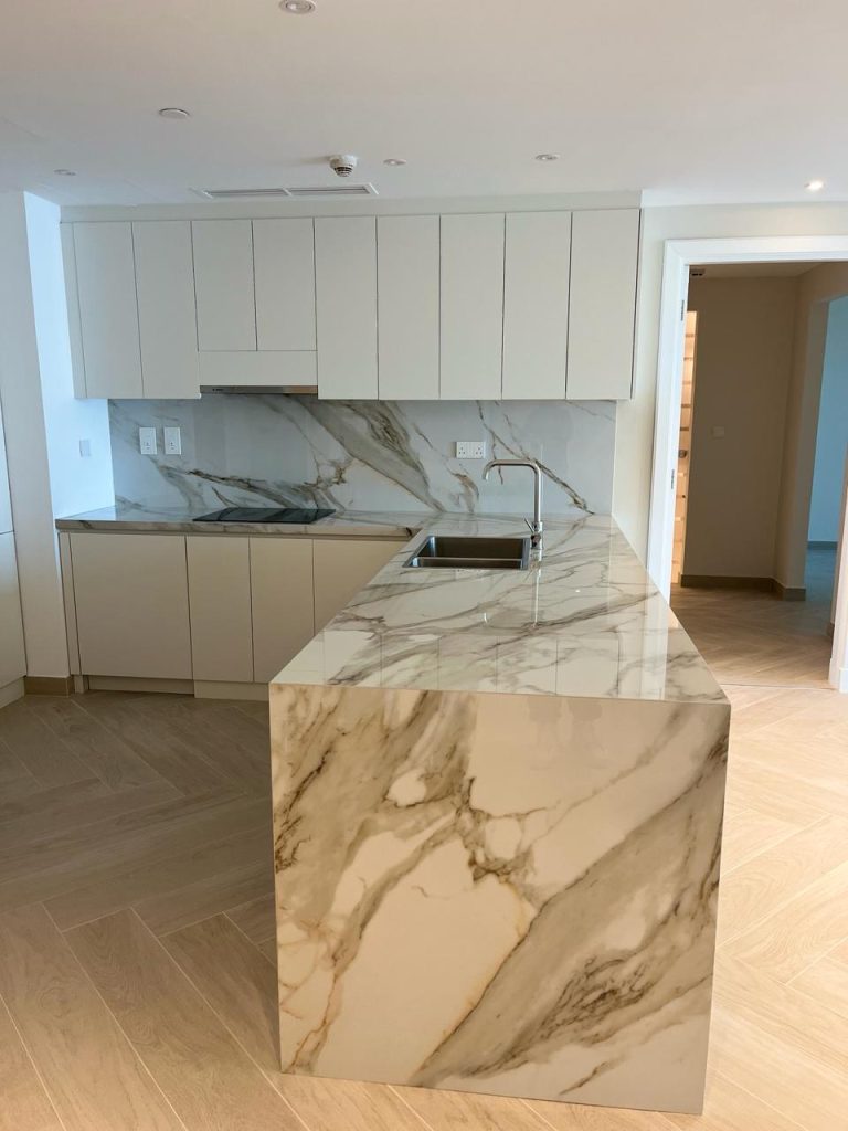 Kitchen island waterfall countertop at Palm Jumeirah Marina Residence 6 by ASM Interiors