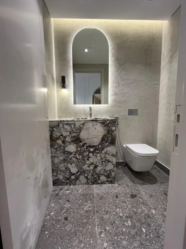 Stone bathroom vanity with arched mirror at Opera Grand