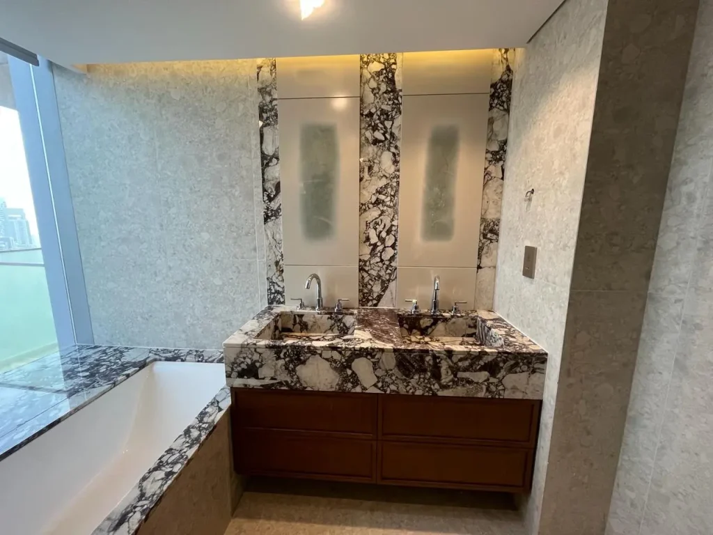 Bathroom Renovation Dubai 4 Double vanity in veined stone with bathtub and backlit mirrors at Opera Grand
