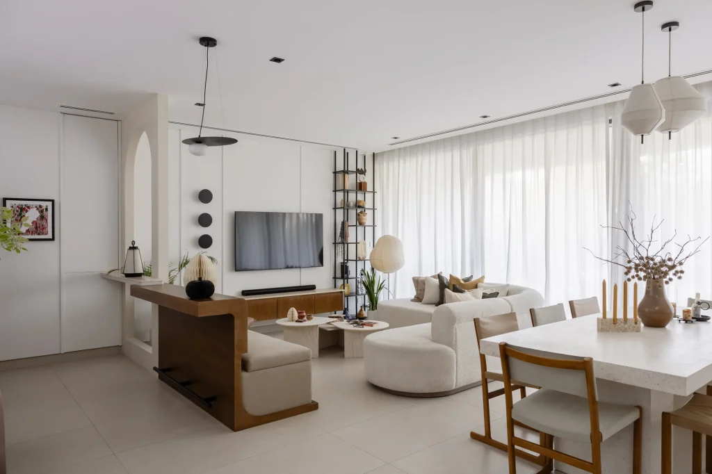 Projects We Have Done 14 Open living and dining area with pale seating, wood-toned furniture and full-height curtains.