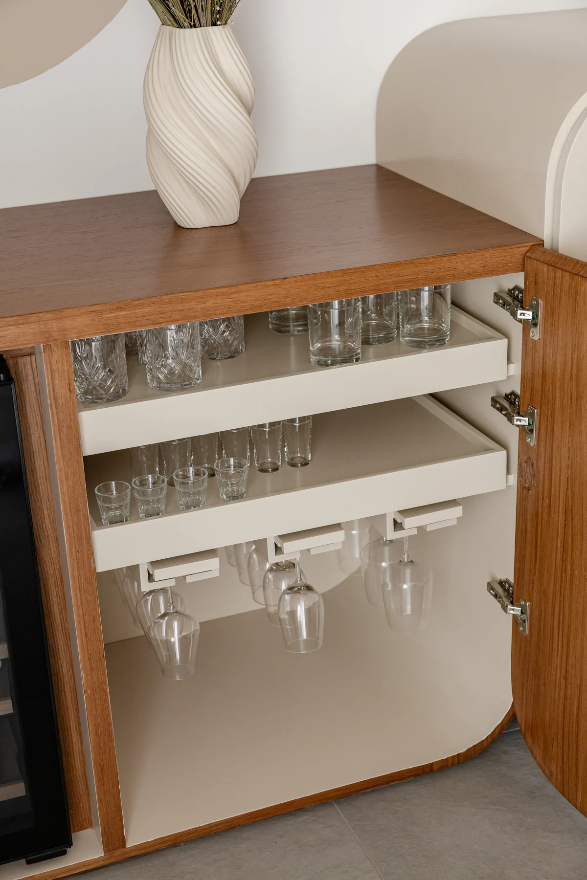 Jumeirah Interior & Joinery 3 Open curved-front cabinet showing pull-out glassware shelves and a stemware rack.